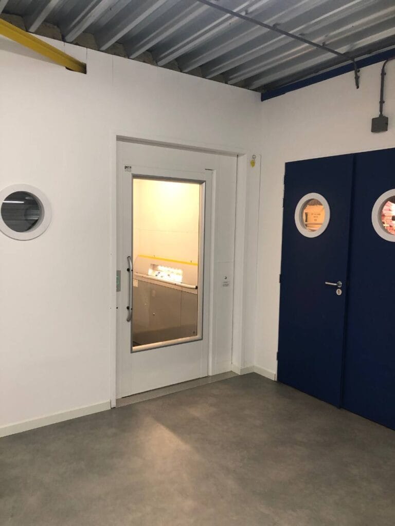 Goederenlift met glazen deur geïnstalleerd in een industriële bedrijfsruimte bij Decrotech Noordwijkerhout