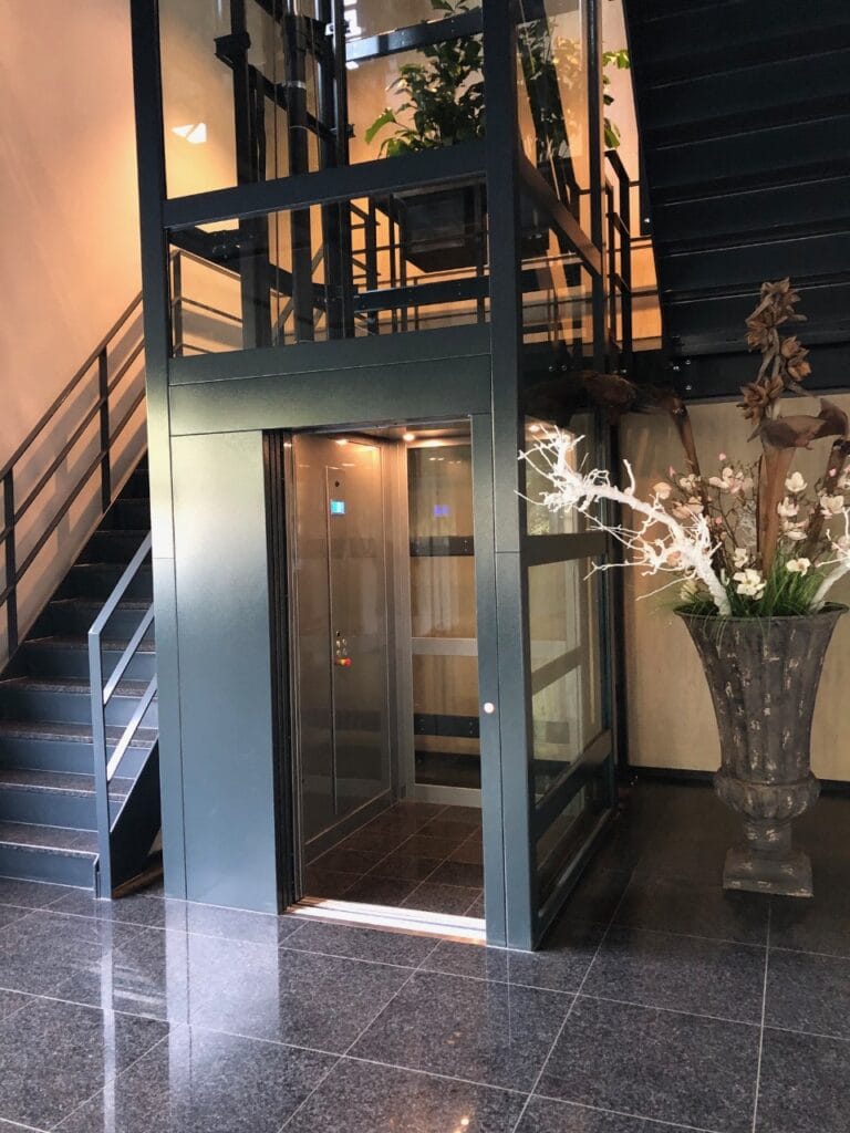 Cabinelift met glazen schacht in stijlvolle lobby van Finder Relais Amsterdam