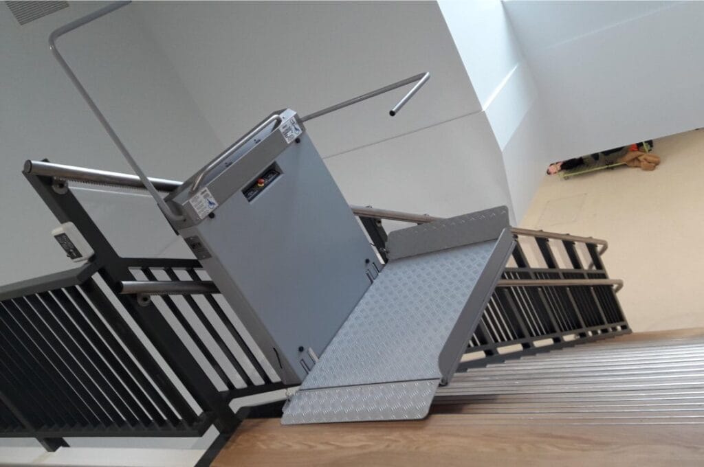 Plateautraplift met uitgeklapte oprijplaat gemonteerd op een binnentrap in Hendrik-Ido-Ambacht