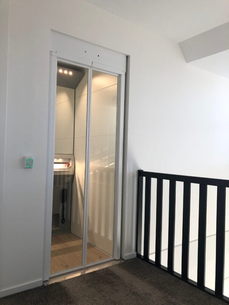 Woonhuislift met glazen schuifdeuren op de overloop in Noordwijkerhout