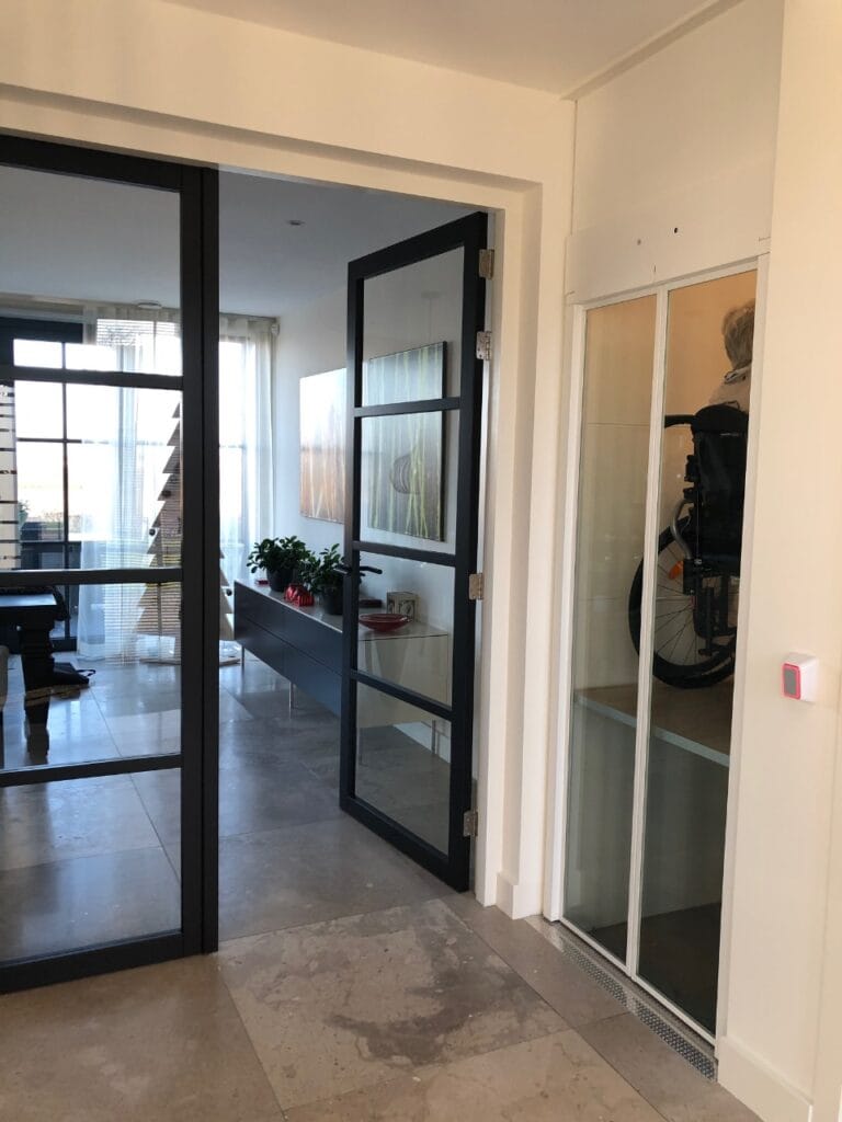 Woonhuislift met glazen schuifdeuren in modern interieur in Noordwijkerhout