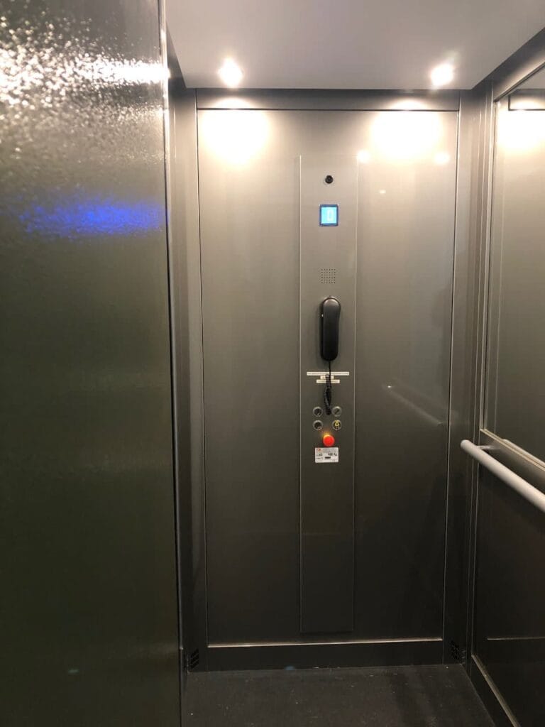 Interieur van een cabinelift met roestvrij stalen wanden en noodtelefoon in Groningen