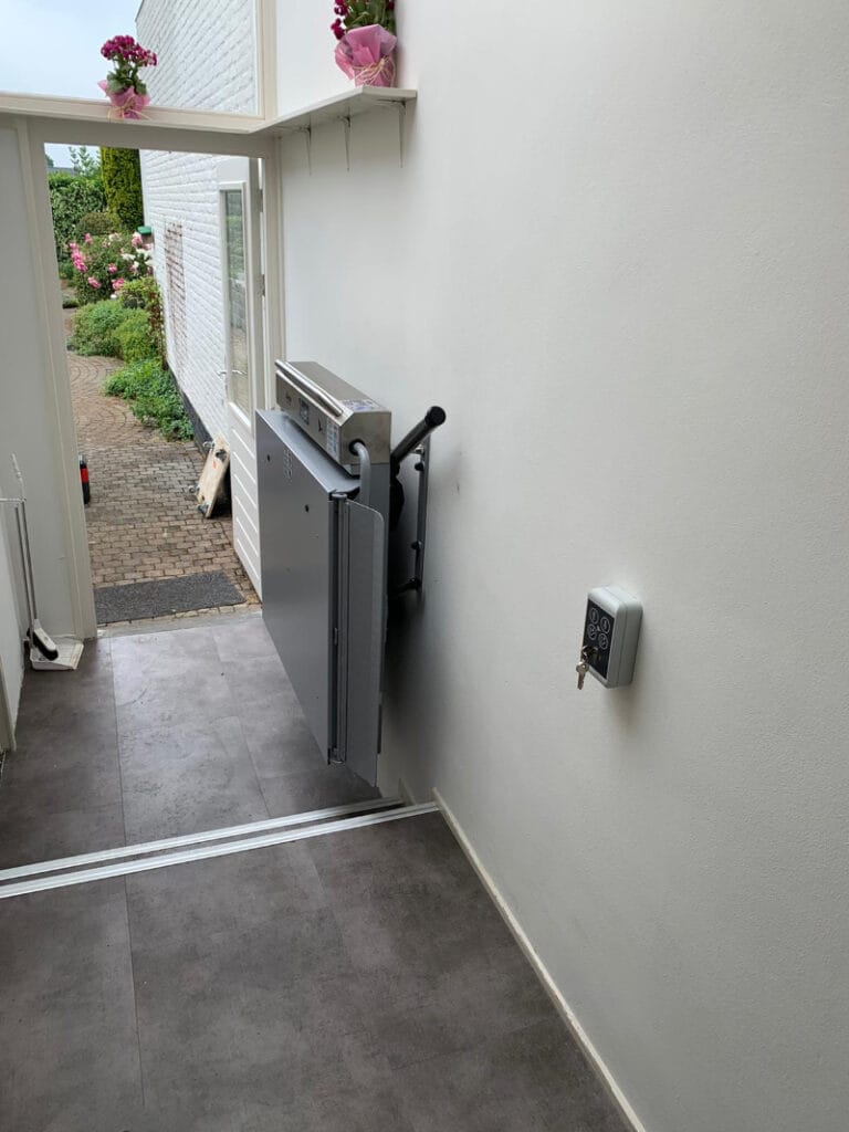 Opgeplooid platform van een platformlift in een woonhuis met zicht op de tuin in Schimmert