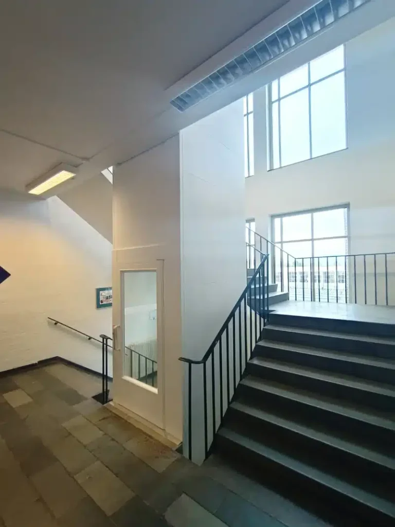 Platformlift naast een brede trap in een schoolgebouw in Den Bosch