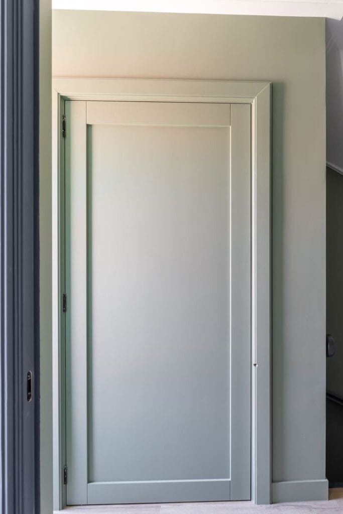 Gesloten liftdeur van een woonhuislift in stijlvolle saliegroen tint passend bij het interieur