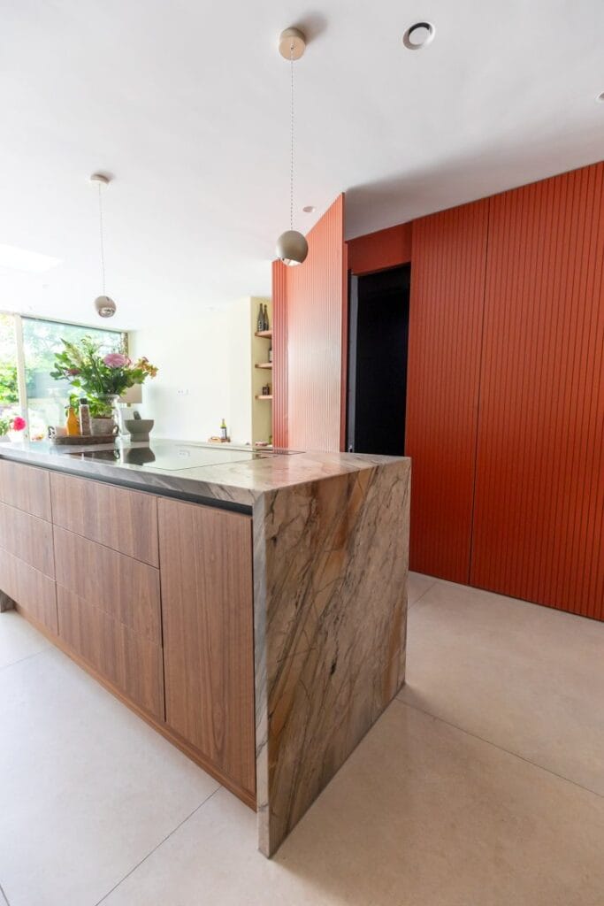 Moderne woonhuislift verborgen achter terracotta lamellenwand in stijlvolle keuken Den Haag