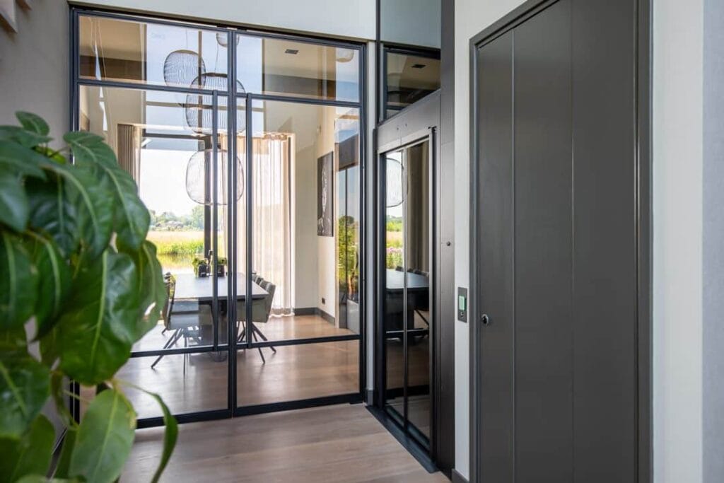 Stijlvolle woonhuislift met donkere afwerking geïntegreerd in modern interieur in Alphen aan den Rijn