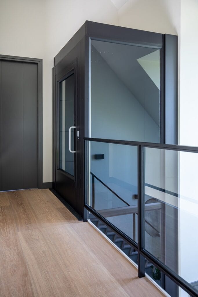 Zwarte glazen woonhuislift op de overloop van een modern woonhuis in Alphen aan den Rijn