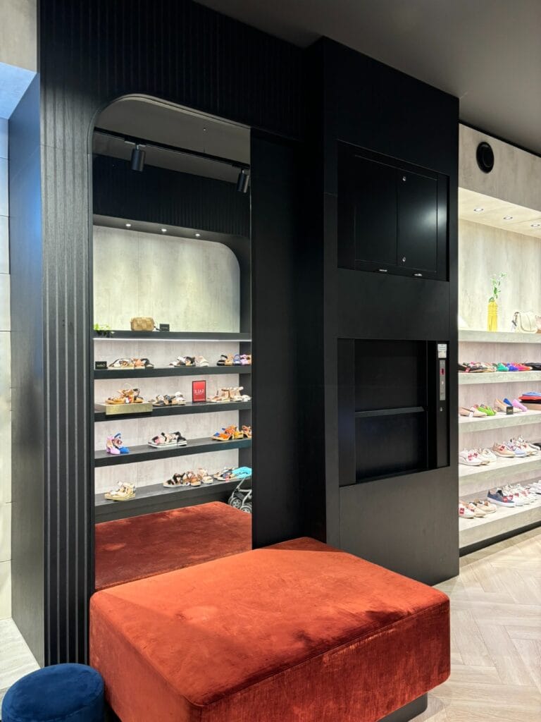 Zwarte goederenlift geïntegreerd in de interieurinrichting van schoenenwinkel Omoda Dordrecht