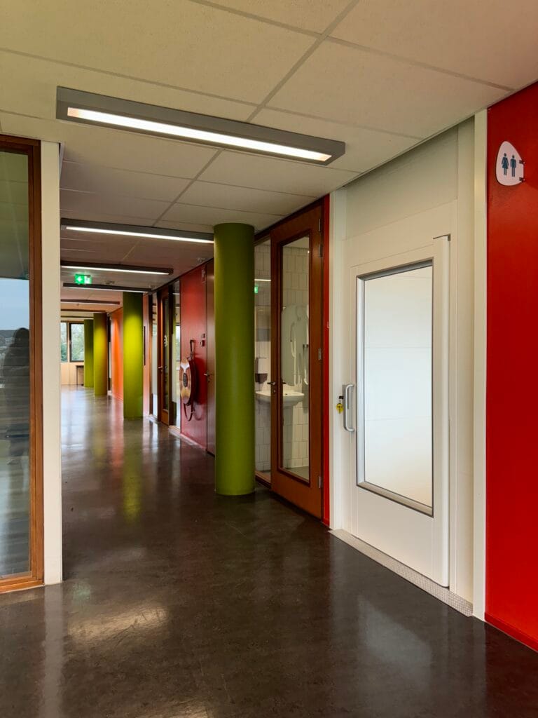 Platformlift geïntegreerd in kleurrijke gang van het Spaarne College in Haarlem