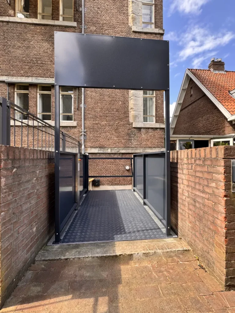 Rolstoellift in antraciet buiten tegen een bakstenen gevel in Utrecht