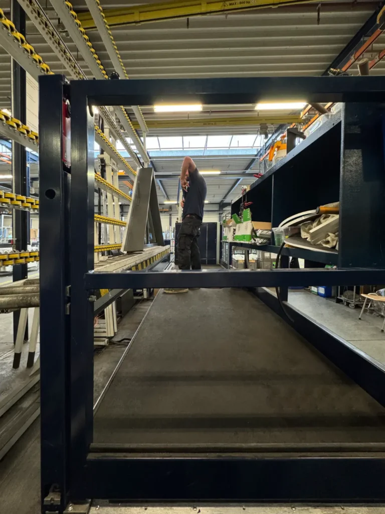 Monteur assembleert een goederenlift in de werkplaats van MTH Lifttechniek