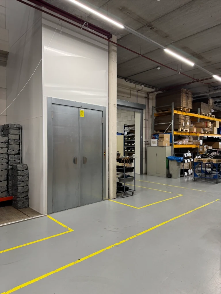 Goederenlift met stalen deuren geïnstalleerd in industrieel magazijn bij Thermo Electric Instrumentation Waddinxveen