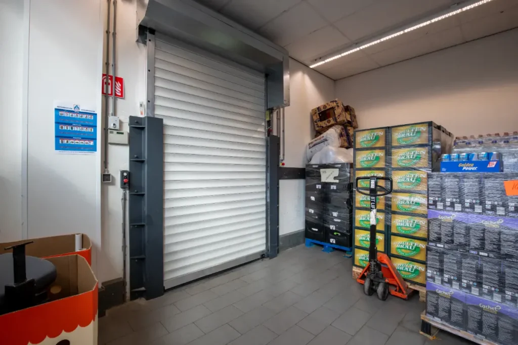 Goederenlift met rolluikdeur in het magazijn van een supermarkt in Amsterdam