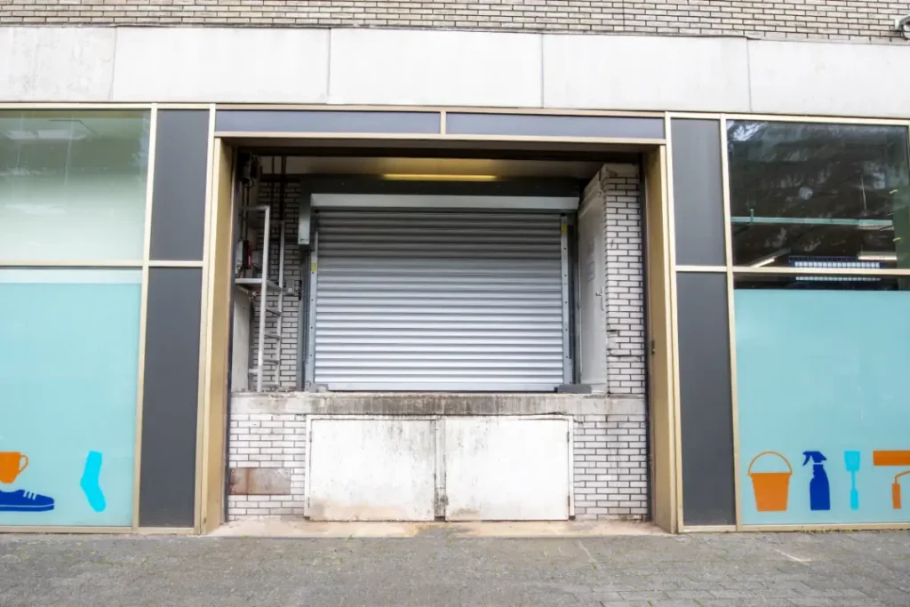 Goederenlift met rolluikdeur aan de buitengevel van een supermarkt in Amsterdam