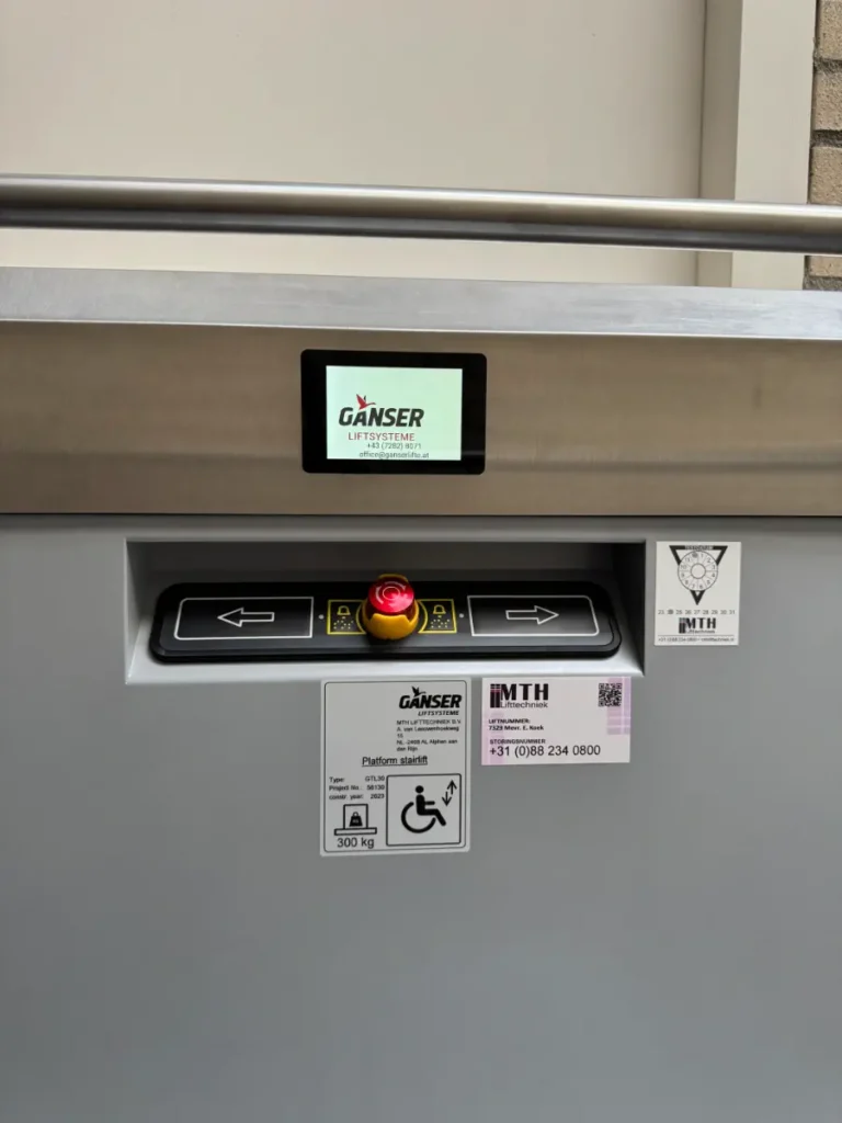 Bedieningspaneel van een plateautraplift van Ganser met noodstopknop en richtingspijlen