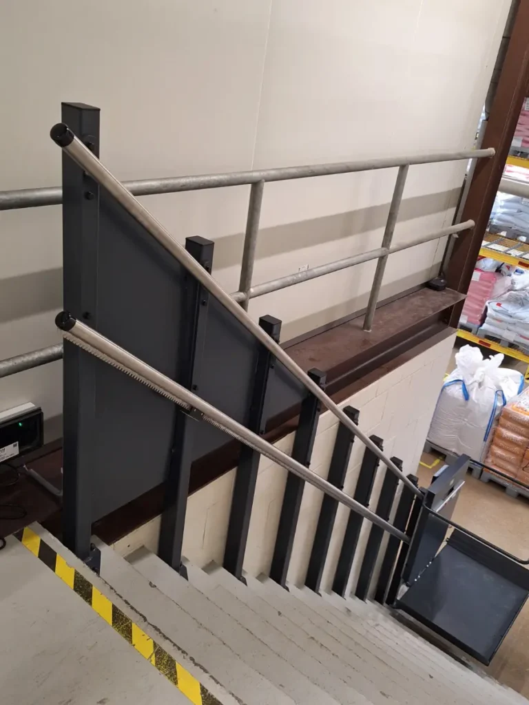 Plateautraplift langs industriële trap in magazijn van Bakkerij Borgesius in Sappemeer