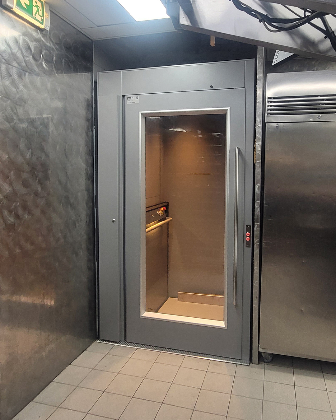 Nami PL 400 personenlift met glazen deur geïnstalleerd in de keuken van McDonald's Amsterdam